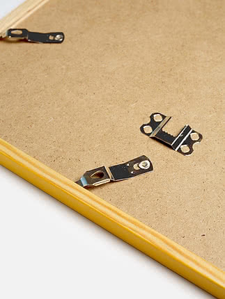 Retro di una cornice quadrata in giallo con il pannello posteriore in MDF e gli attacchi metallici per appenderla