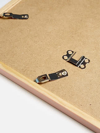 Retro di una cornice quadrata in rosa pastello con il pannello posteriore in MDF e gli attacchi metallici per appenderla