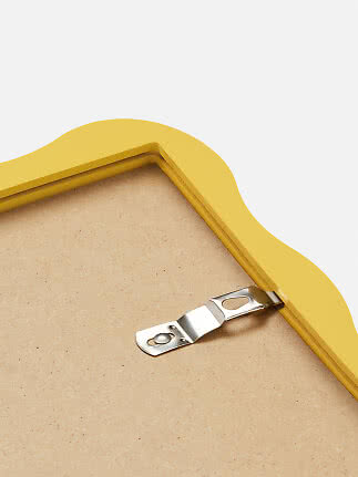 Back of a yellow wavy frame with metal hanging hook