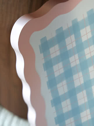 Close-up of tray with wavy pink rim and light blue check pattern