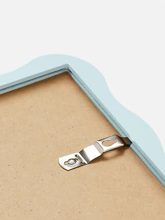 Close-up of the back of a light blue wavy frame with metal hanging hook