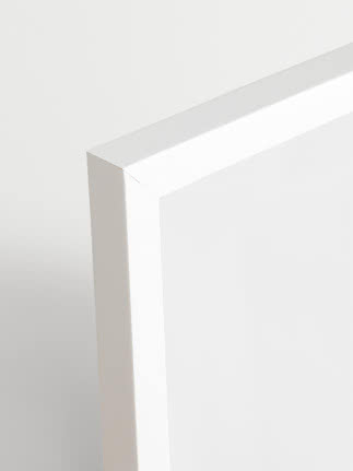 Nahaufnahme der Ecke eines weißen minimalistischen Tisches oder Schranks vor hellem Hintergrund