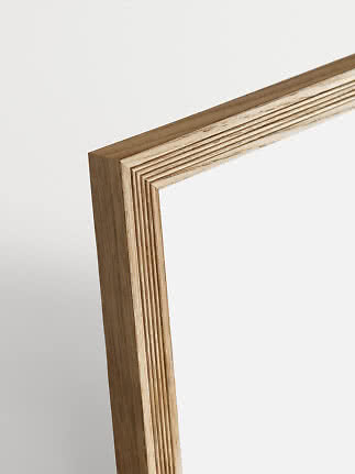 Nahaufnahme einer hellen Holzrahmenecke mit sichtbaren Schichten und Maserung