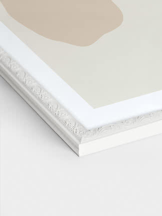 Close-up of white Versailles picture frame with ornate floral edge