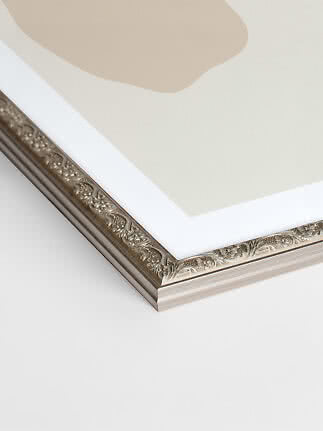 Close-up of silver Versailles picture frame with ornate pattern and white mat border