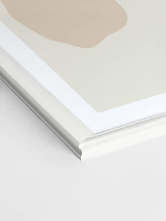 Close-up of white Madeleine picture frame with decorative edge and mat board