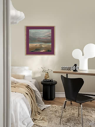 Paesaggio dai colori tenui in passepartout prugna e cornice in rovere su una parete della camera da letto, sopra una scrivania con lampada bianca