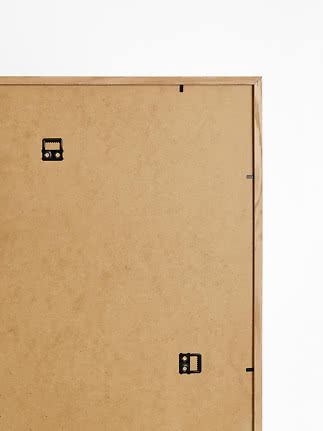 Back of a light wood picture frame with hanging brackets