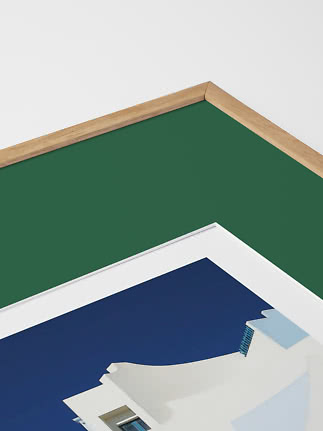 Close-up of framed poster with natural wood frame, green border, and blue-white artwork