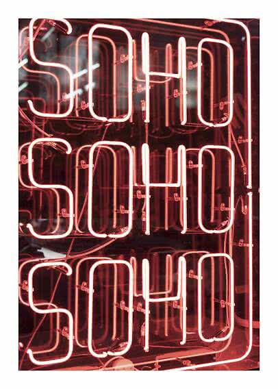 Insegna al neon rosa con scritta SOHO SOHO SOHO su sfondo scuro