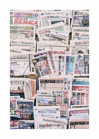 Présentoir rempli de journaux et magazines internationaux en plusieurs rangées
