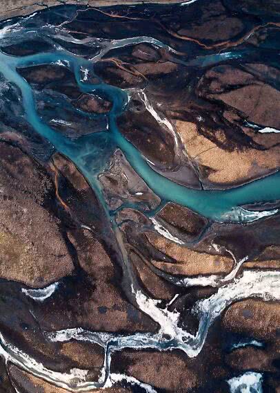 Vista aerea di un fiume turchese che serpeggia tra scuri banchi di sabbia