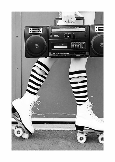 Schwarzweißfoto einer Person auf Rollschuhen mit gestreiften Kniestrümpfen und großem Ghettoblaster