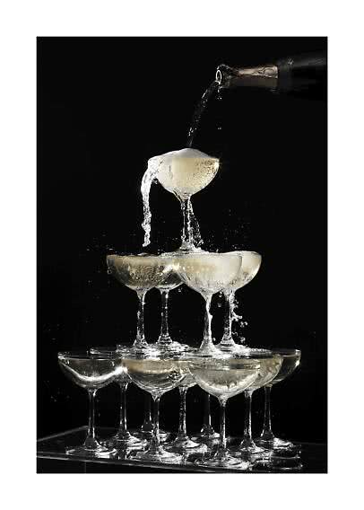 Champagne versé dans une pyramide de coupes sur fond noir