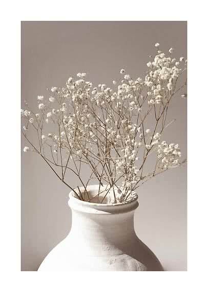 Fiori bianchi secchi in un vaso bianco opaco su sfondo beige chiaro