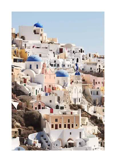White houses with blue domes on a sunny Santorini hillside under a clear blue sky