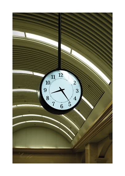 Ronde hangende klok onder gebogen plafond met lichtstroken binnen