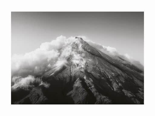 Photo en noir et blanc d’un sommet montagneux entouré de nuages