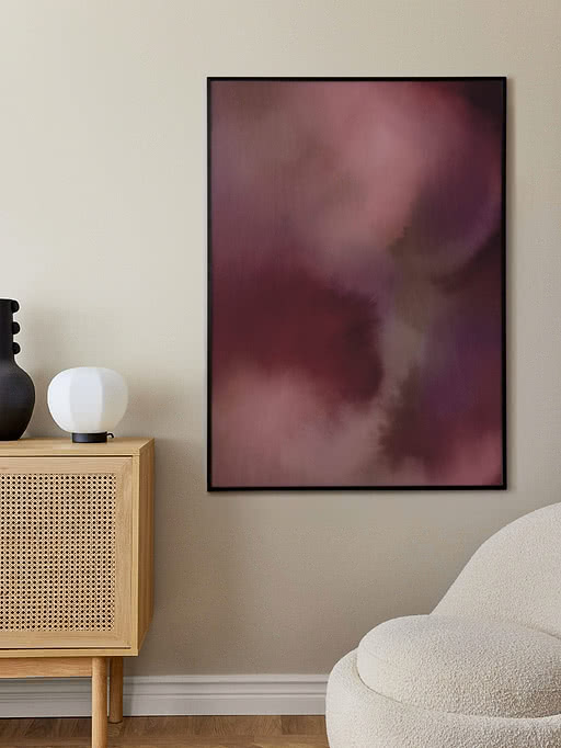 Abstrakt plakat i rosa og bordeaux nuancer i sort ramme på beige væg
