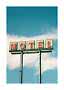Vintage-MOTEL-Schild auf hohen Pfosten vor blauem Himmel mit Wolken