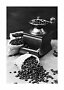 Vintage kaffekværn med kaffebønner i små juteposer og spredte bønner, sort-hvidt foto