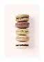 Stapel aus fünf Macarons in hellen und braunen Tönen vor blassrosa Hintergrund