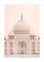 Front view of the Taj Mahal’s white marble dome and facade against a soft pink sky