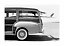 Foto in bianco e nero di una station wagon vintage con tavola da surf sul lato vicino alla costa