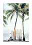 Four surfboards under palm trees on a calm beach by the sea