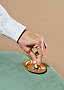 Hand in wit overhemd dooft sigaret in gouden asbak op groene fluwelen stoel