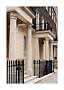 Classic townhouse facade with cream columns, black railings and balconies
