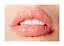 Nærbillede af læber med skinnende lyserød lipgloss og synlige tænder