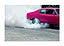 Pinker Oldtimer macht einen Burnout, Rauch steigt von den Hinterreifen auf