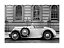 Foto in bianco e nero di una cabriolet d’epoca davanti a un edificio con finestre ad arco