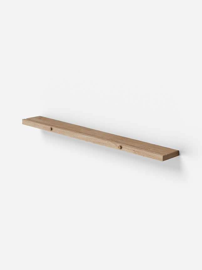 Étagère murale fine en bois clair fixée sur un mur blanc