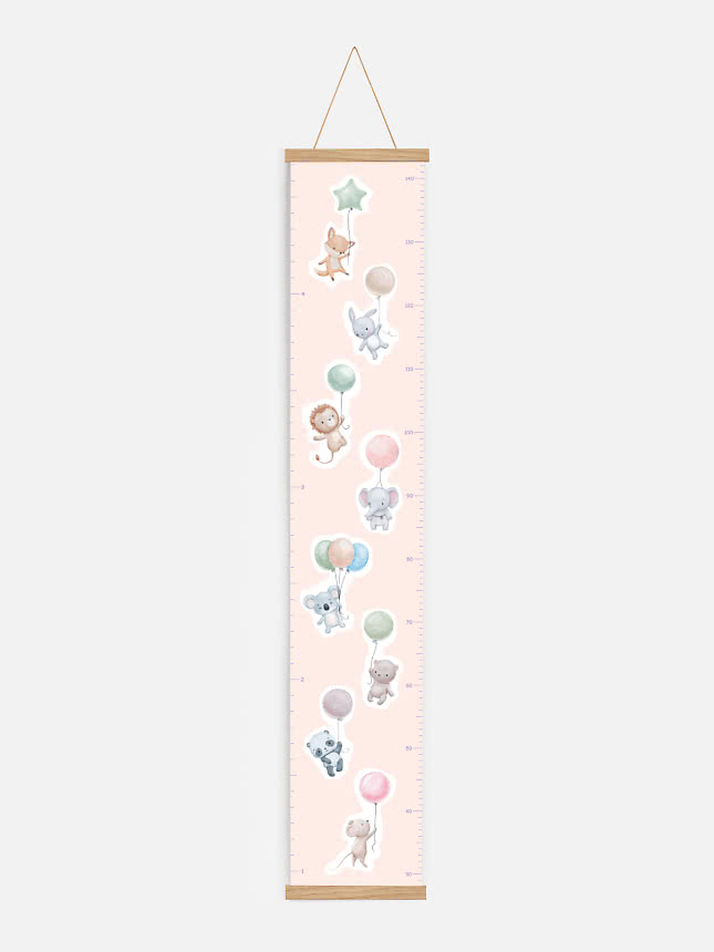 Toise rose avec animaux mignons et ballons, suspendue entre deux baguettes en bois
