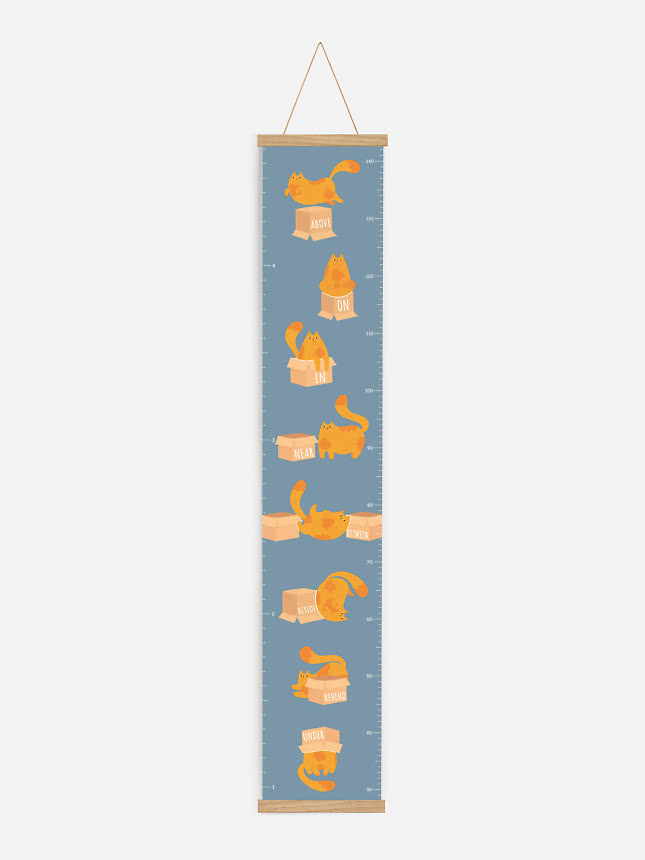 Blaue Messlatte mit orangefarbenen Katzen und Kartons in verschiedenen Positionen, im Holzrahmen.
